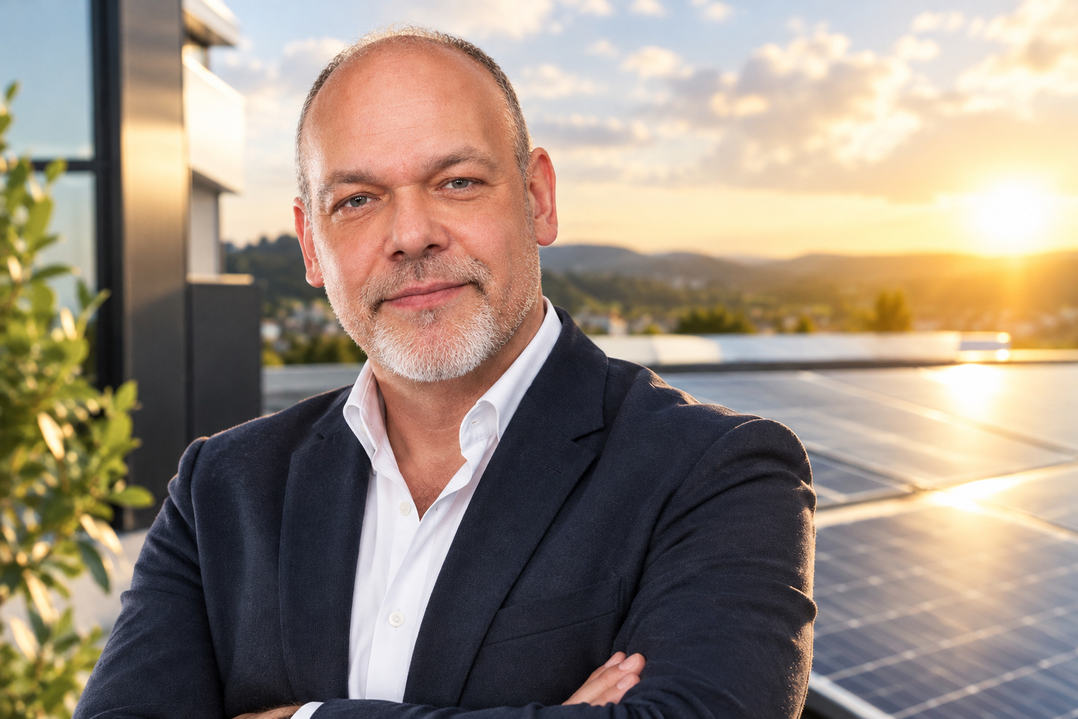 Harald Roßbach, Geschäftsführer von NOVOLT, vor Photovoltaik-Modulen auf einem Dach